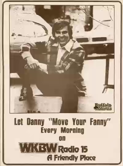1981-era low-quality black-and-white photo of a man sitting near a car with the text, “Let Danny ‘Move Your Fanny’ Every Morning on WKBW Radio 15, A Friendly Place”