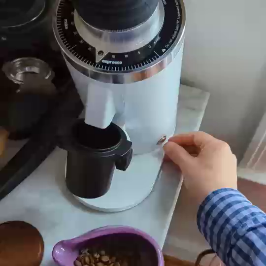A 12 inch high, 5 inch diameter white cylinder, set at maybe a 20 degree angle with a chute on the front that empties into a metal cup braced under it. The top is a grind size dial with a metal receptacle with a rubber bellows for accepting beans. I pour a bunch of beans into it and they come out the chute as a fine powder.