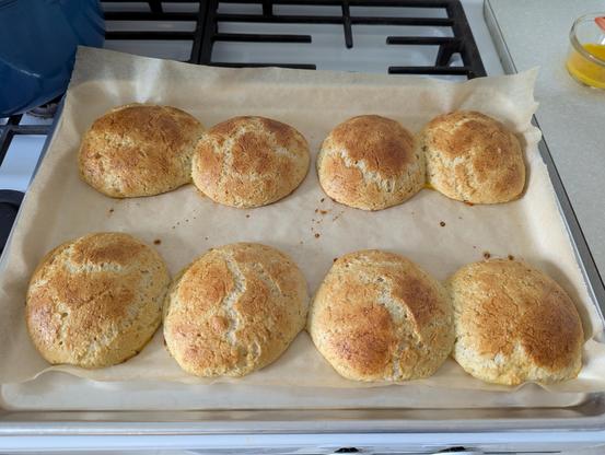 The same eight flattened balls, but now baked into flattened rolls, some having spread and made contact with one another, with a nice golden brown on their tops.