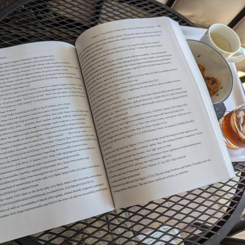 The book open to page 247 showing a full two-page spread of links to supporting materials, covering footnotes 7 through 31; the espresso cup is empty, the fizzy coffee soda nearly empty, and the pretzels are one shy of being empty.