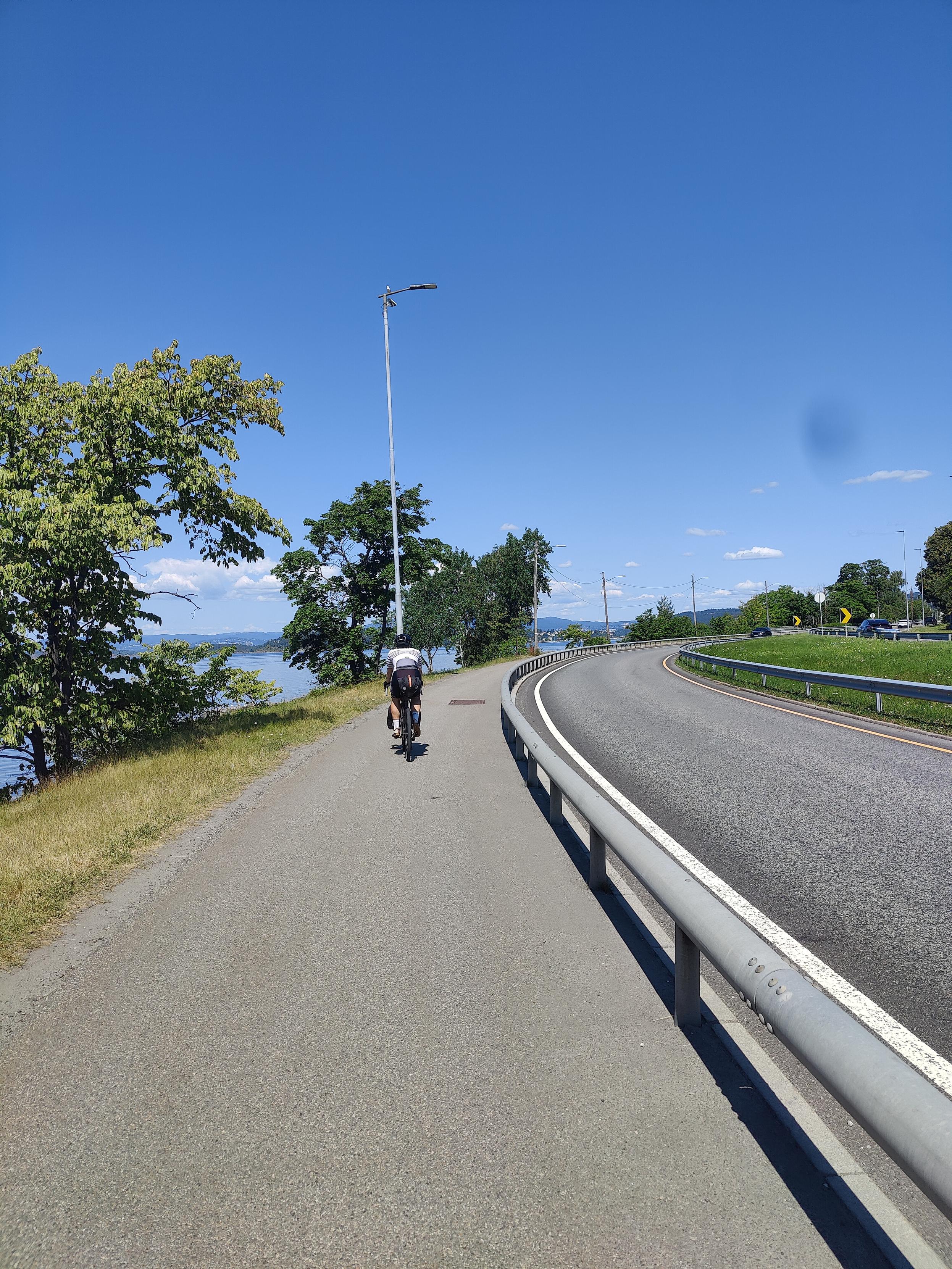 Cyclist on a cycling path. Oslo fjord in the background.