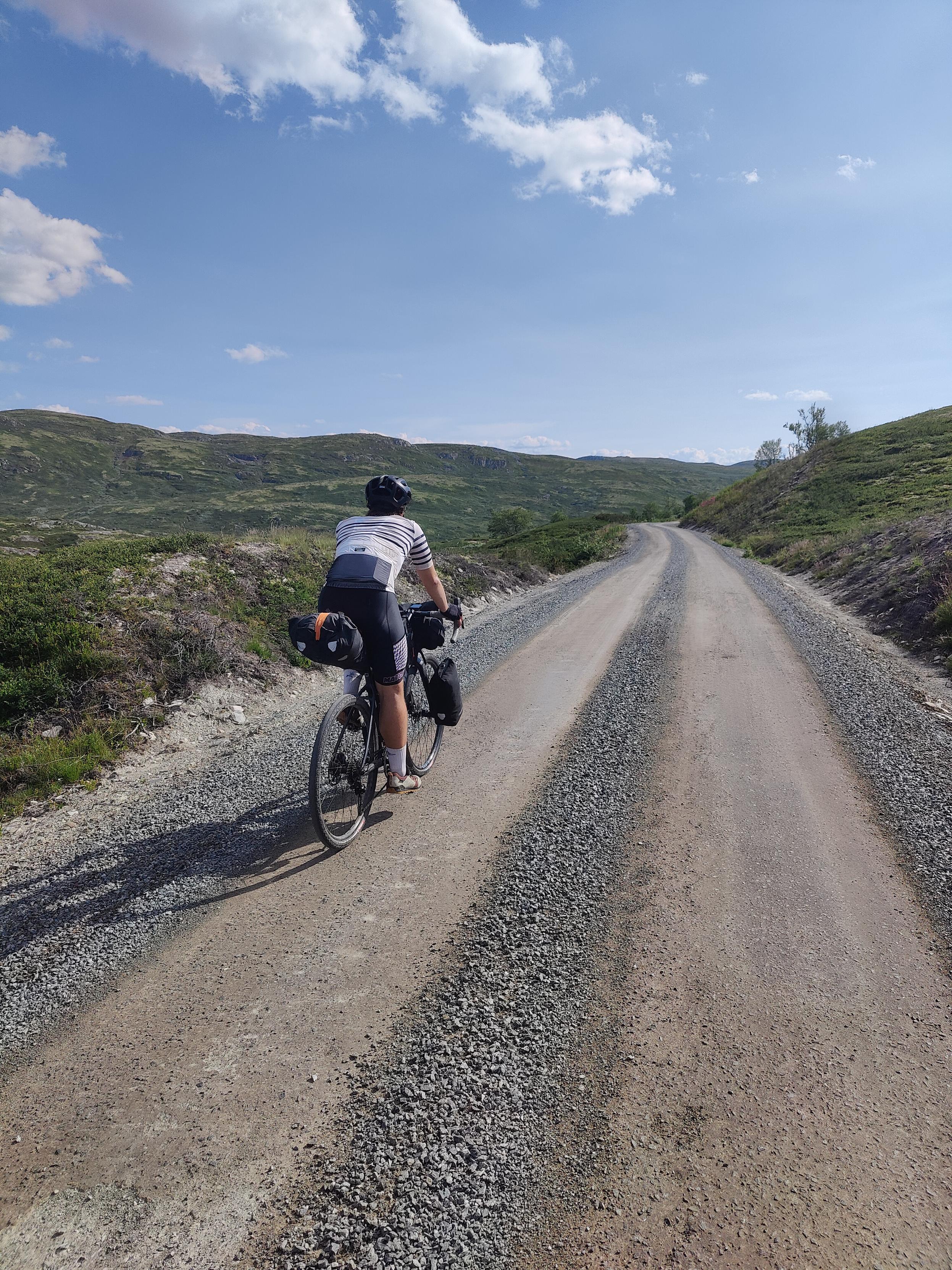 Cyclist in gravel road.