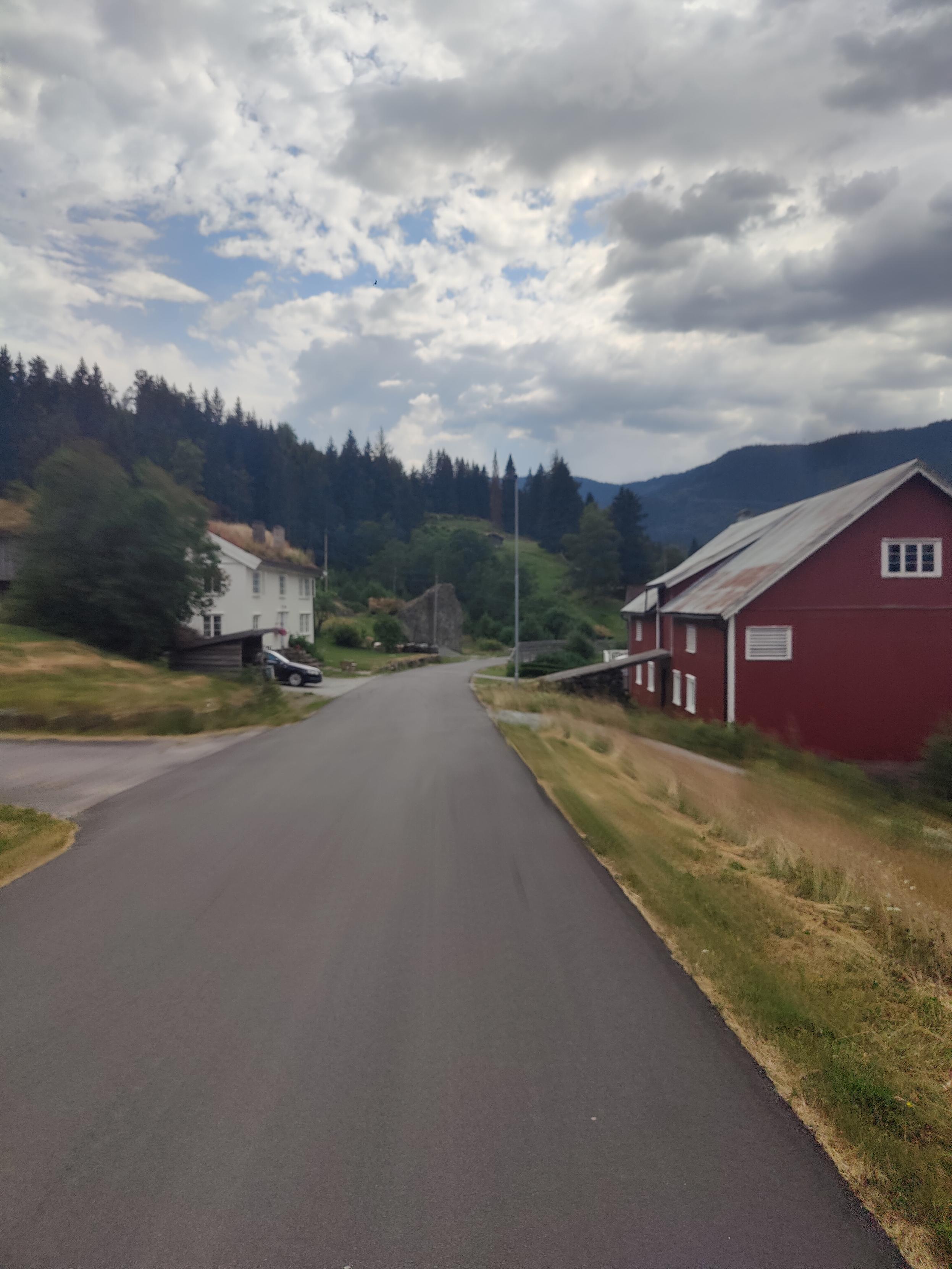 Empty road, red house on the right.