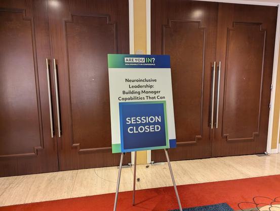 Sign with session title: “Neuro nclusive Leadership: Building Manager Capabilities That Can…” but the rest of the title is hidden by a big blue “SESSION CLOSED” sign.