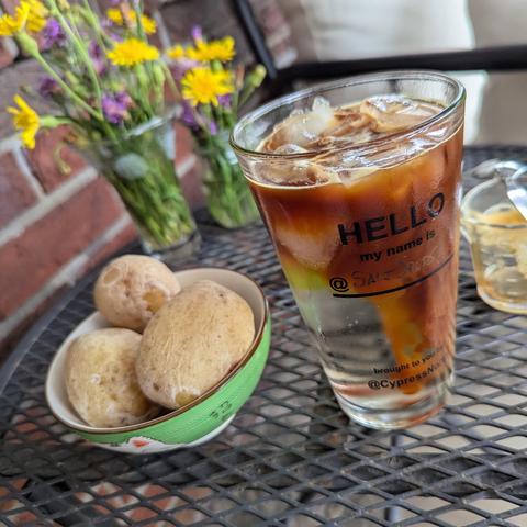 A pint glass of ice and club soda with espresso cascading throug it alongside a small bowl with five salt potatoes.
