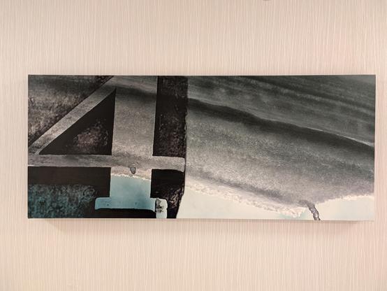 A wide photo illustration on canvas that may be a close-up of ice under a table or building eaves, with the left third seemingly a black patch of woodblock stamp with the number 4 in the negative space.